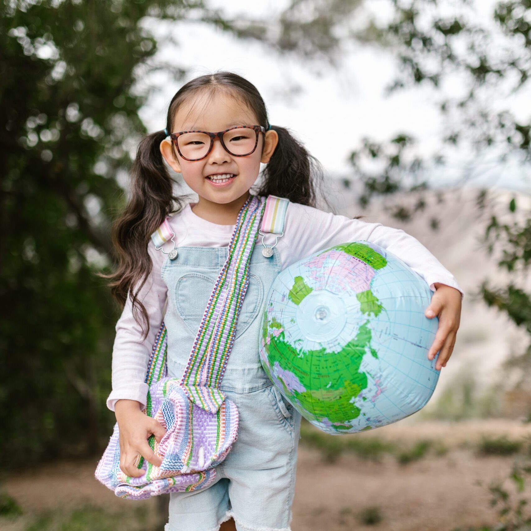 child with a world globe beach ball